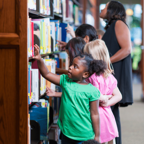 child reading a book surrounded by bookshelves filled with various books