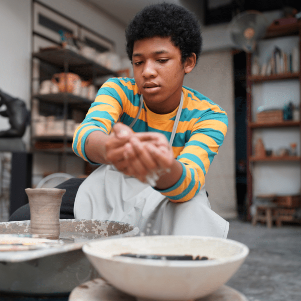 Young Woman hand potter making clay vase in pottery workshop