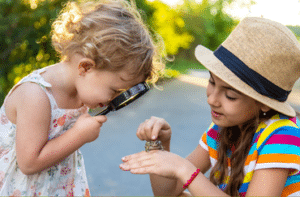 Kids looking at frog through magnifying glass