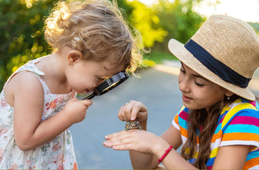 Kids looking at frog through magnifying glass